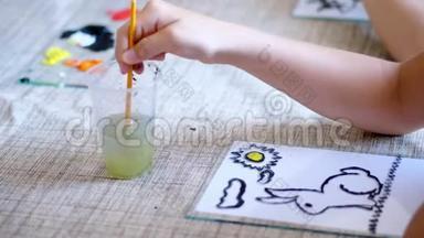 绘画教室，特写，孩子们`手在玻璃里洗一把画笔画画.. 女孩用颜色画画，主人