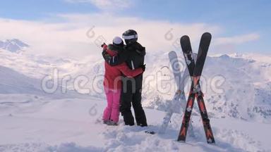 恋爱中的情侣站在雪山的顶端，双手移动