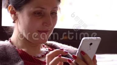 女人在智能手机上使用应用程序，在咖啡馆里喝咖啡，<strong>微</strong>笑着在手机上发短信。 美丽的多元<strong>文化</strong>青年