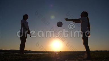 女孩青少年在日落时打球。 慢动作。