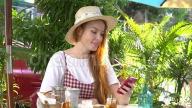女孩在户外喝茶时使用手机应用程序。