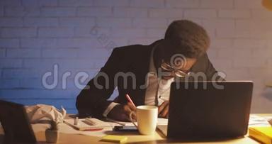 年轻的黑人商人带着笔记本电脑和文件在夜间办公室工作。 他在文件上签字。 <strong>商务</strong>