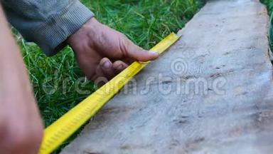 男建筑工人用卷尺或标尺测量木板