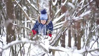 快乐的童年——一个快乐的小男孩在冬天的雪林里<strong>爬树</strong>