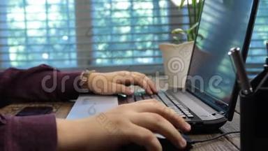 人在笔记本电脑上工作，使用鼠标和笔记本键盘。