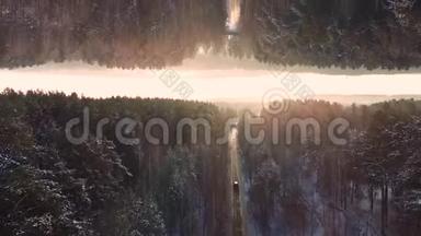 车行驶在森林中的冬季乡村道路上，鸟瞰日落天空背景，镜面<strong>视界</strong>效果.. 车辆