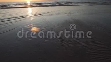 深红的日落，晴朗的天空和镜子，像水中的倒影-带状的沙子和波浪-拉脱维亚图亚-4月13日