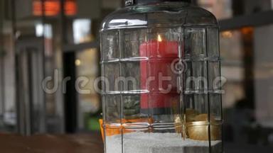 漂亮的玻璃烛台上有一支红色的大蜡烛，烛台内有一支红色的蜡烛，矗立在烛台上