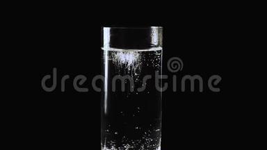 阿斯匹林片剂随着水从玻璃<strong>底部</strong>滑落，空气气泡从玻璃<strong>底部</strong>在矿物瓦中上升