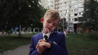 在一个穿着商务服的小孩手上，用黑色的表带合上智能手表的特写镜头。 运动智能手腕使用。