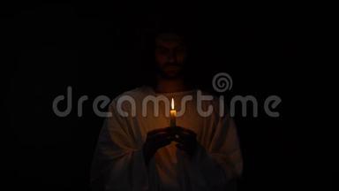 耶稣复活前，戴荆棘冠冕的圣人，在黑暗中持烛