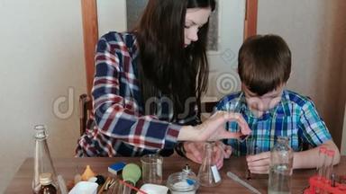 在家里做化学实验。妈妈和儿子正在用红色颜料和水做实验。