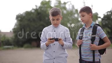 两个男孩放学后玩网络游戏。 小男孩微笑，用电话