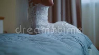 美丽的新娘在镜子里欣赏她的婚纱礼服，为她的长袖婚纱花边设计做准备