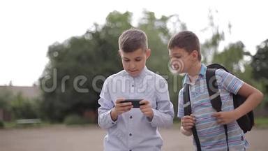 两个男孩<strong>放学</strong>后玩网络游戏。 小男孩微笑，用电话