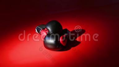 相机运动，黑色和<strong>红色</strong>拳击手套躺在<strong>红色</strong>的地板上，在美丽的人造<strong>光线</strong>下