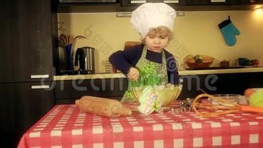 可爱的小厨师女孩，带厨师帽和围裙，混合面粉，准备沙漠
