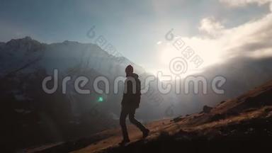 在美丽的日落中，一个人在山的边缘行走的史诗般的照片的鸟瞰。 剪影