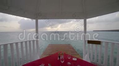 热带海滩上的浪漫气氛，在海边的平房里，桌上摆着玻璃杯和碟子