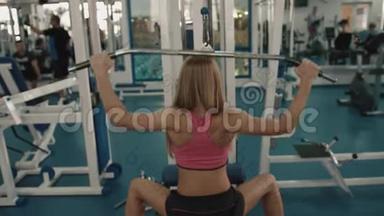 运动的金发女运动员在健身站上打铁的时候，她的后视角暖和了起来。 4k.