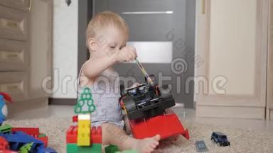 可爱的小男孩在家里地板上玩一个大汽车玩具。 小孩子在室内玩玩具车。 未来司机