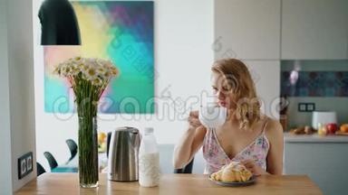 快乐的女孩在家厨房吃早餐。 美丽的白种人女人