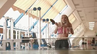 漂亮的金发女运动员正在健身房打<strong>乒乓球</strong>或<strong>乒乓球</strong>。 4K录像。