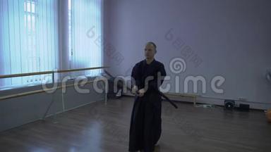 剑道大师用卡塔纳剑表演priyomyas，在运动大厅里<strong>绊倒</strong>kata。