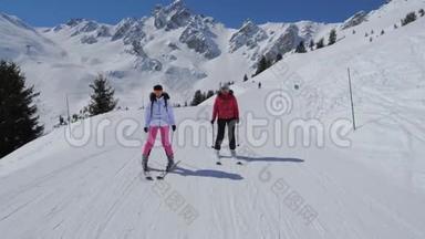 两名女子滑雪者滑下冬季山的理想斜坡
