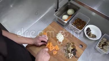 厨师切胡萝卜。 烹饪过程。 手切胡萝卜。 厨师把胡萝卜切成薄片。 反击。 顶部视图