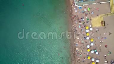 空中：海滩的俯视图.. 人们在海中洗澡，在岸上打着木制的<strong>沙滩伞</strong>