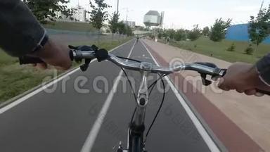 在城市的街道上骑自行车的人。 双手掌舵的视野