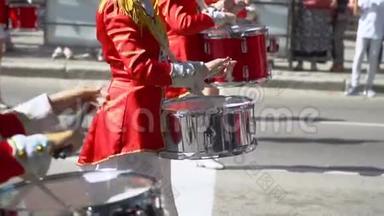 穿红色服装的鼓手女孩在街头表演