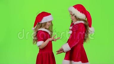 穿红色西装的孩子玩<strong>新年</strong>`<strong>游戏</strong>，微笑，玩得开心。 绿色屏幕