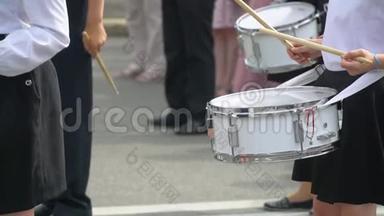 街头表演的节日游行的鼓手女孩和男孩的服装在城市街头。 女孩手部特写