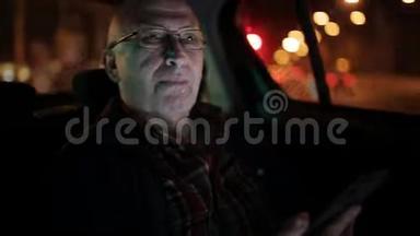 一个在出租车里用手机的老人。 他在网上发短信、查看邮件、聊天或新闻。 晚安。