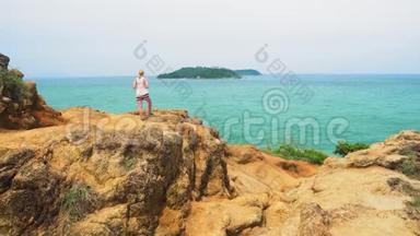 女人站在热带海洋的岸边，眺望远方.. 在热带岛屿上旅行