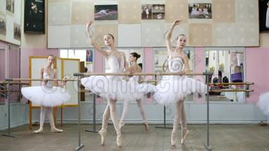 在芭蕾舞厅里，穿着白色芭蕾舞裙的女孩，穿着芭蕾舞裙的女孩，包在芭蕾上，向前排练着弯曲曲，年轻的芭蕾舞演员