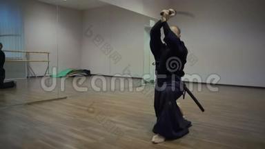 肯多卡大师骄傲地用katan剑挥杆，用镜子在体育馆表演kata