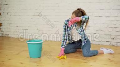 震惊的女人用很多工具打扫房子。 年轻疲惫的女孩在桶里扔一块抹布。