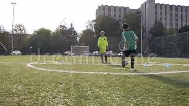 两个男孩在足球训练中踢足球。