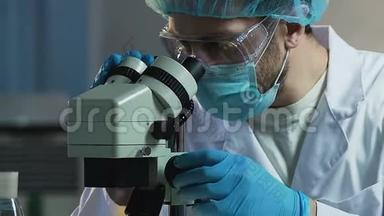 制药工业实验室用显微镜工作的男科学家