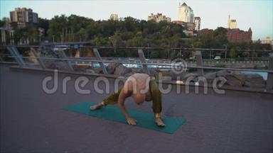 秃头青年瑜伽在晨曦都市景观背景下练习体式