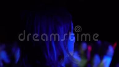 在户外节日晚会音乐会上跳舞的女人原多彩灯模糊背景