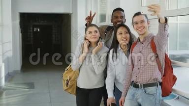 一群多民族的学生在大学走廊里站在智能手机相机上自拍。 偷鸡仔