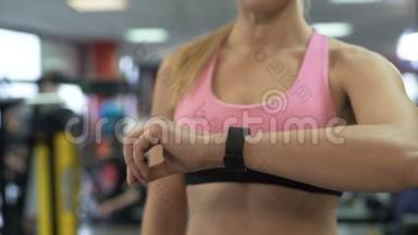 女士使用健身手环和移动应用程序检查她的训练进度