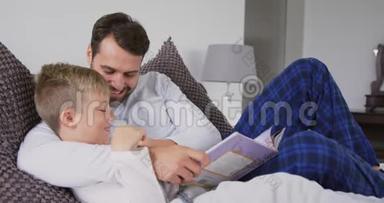 父亲和儿子在卧室的床上<strong>读故事</strong>书