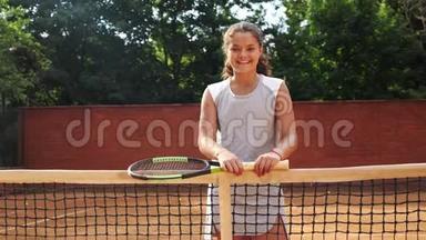 漂亮的年轻网球运动员站在球拍上的肖像。