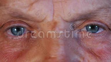 瞳孔的收缩.. 中年妇女美丽的蓝眼睛虹膜。 有皱纹的老祖母