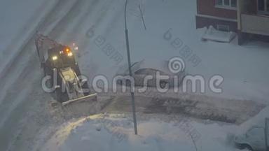 拖拉机从雪地上清理院子里的道路。 拖拉机清理雪刷